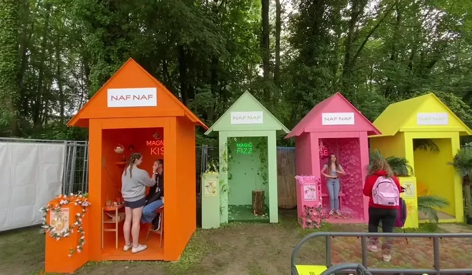 Cabines colorées Naf Naf installées dans un festival en forêt