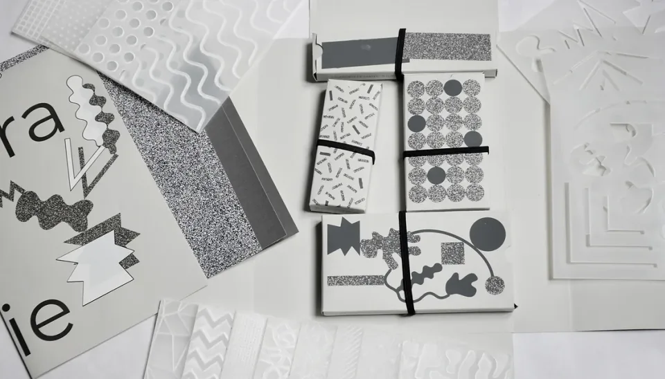 Éléments du kit : pochoirs, plaques texturées et boîtes de cartes