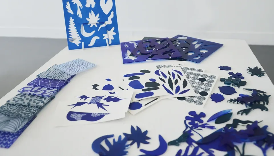 Version bleue du kit : pochoirs et formes découpées sur une table blanche