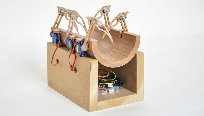 Prototype du Tactilophone : berceau en bois pour l'avant-bras, pinces actionnées par servomoteurs
