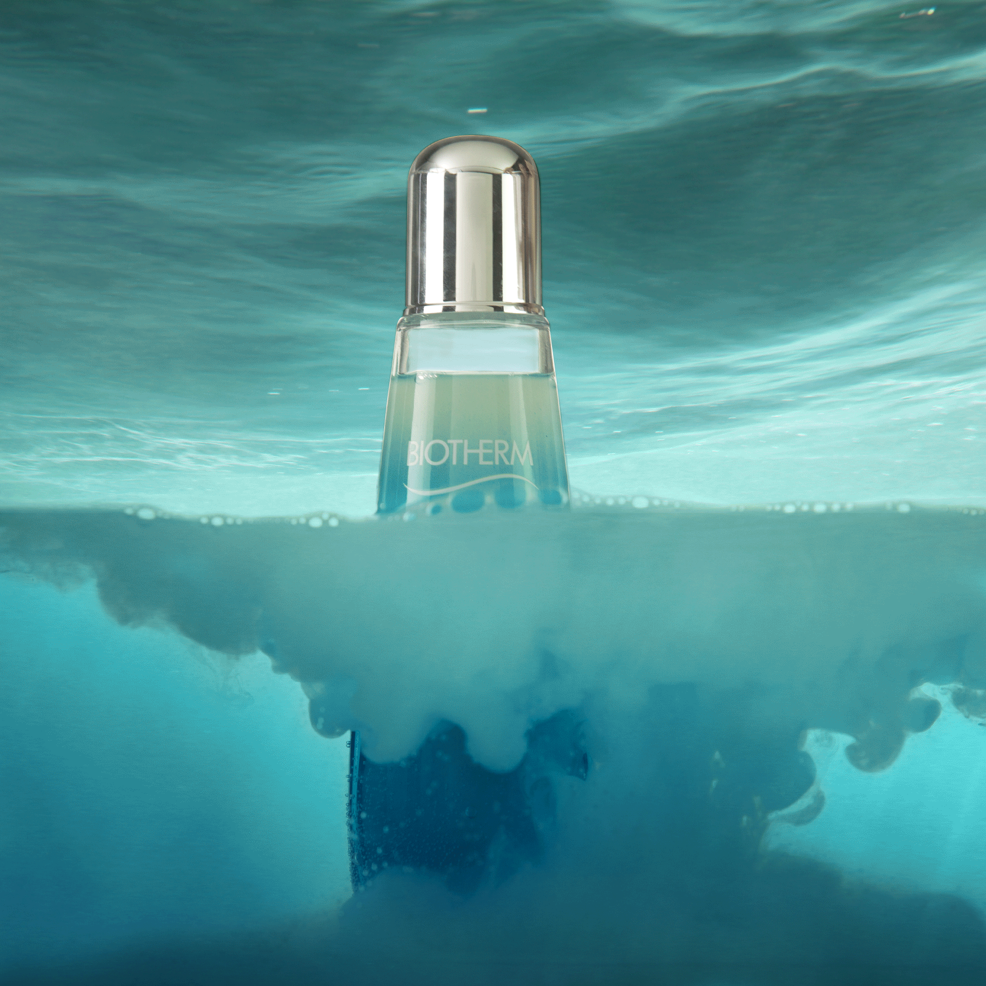 Flacon Biotherm à moitié immergé dans une eau turquoise